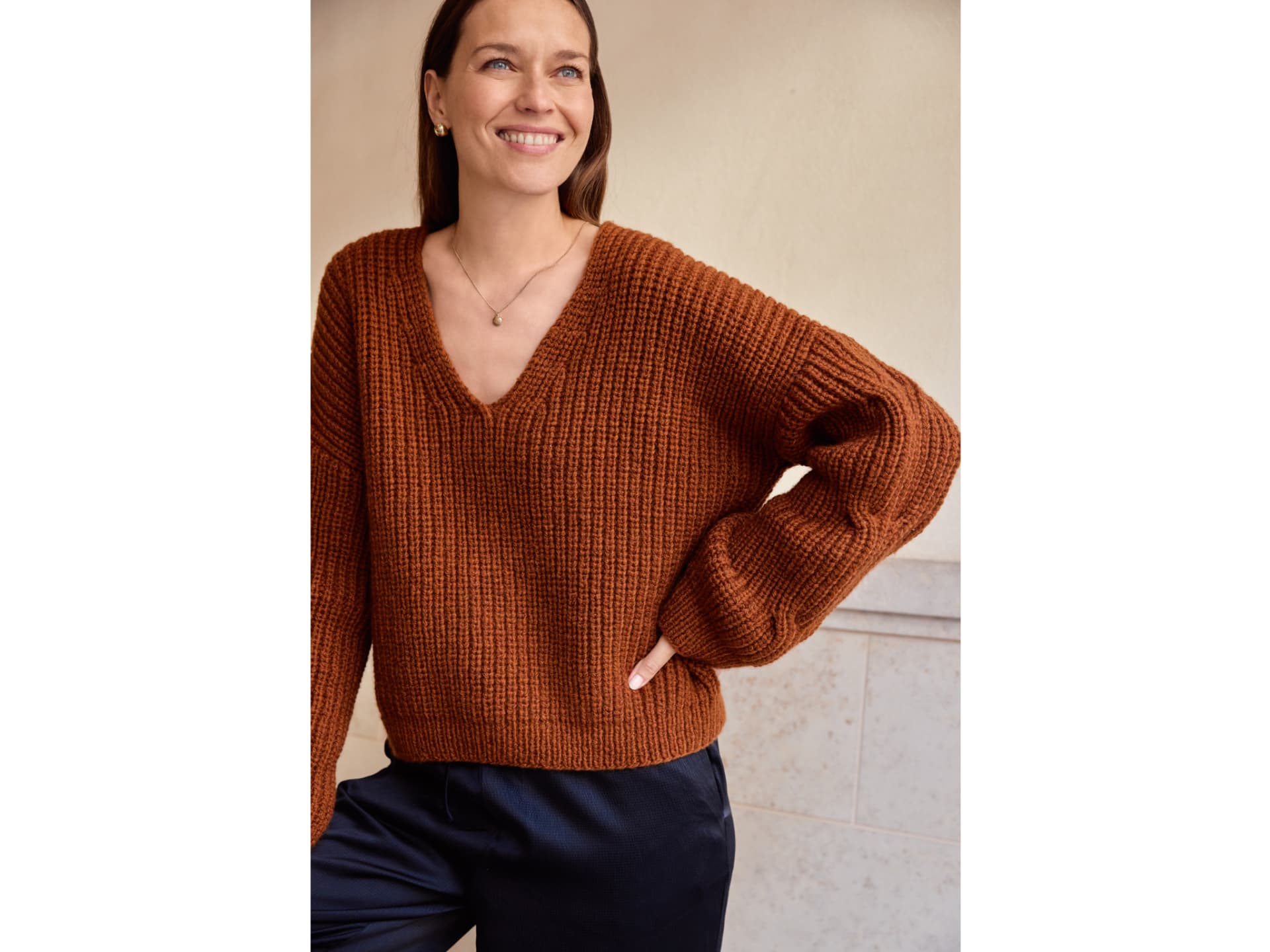 Strickanleitung für den karamellfarbenen Kaschmirpullover mit V-Ausschnitt von Lana Grossa Model mit karamellfarbenem Kaschmirpullover mit V-Ausschnitt von Lana Grossa