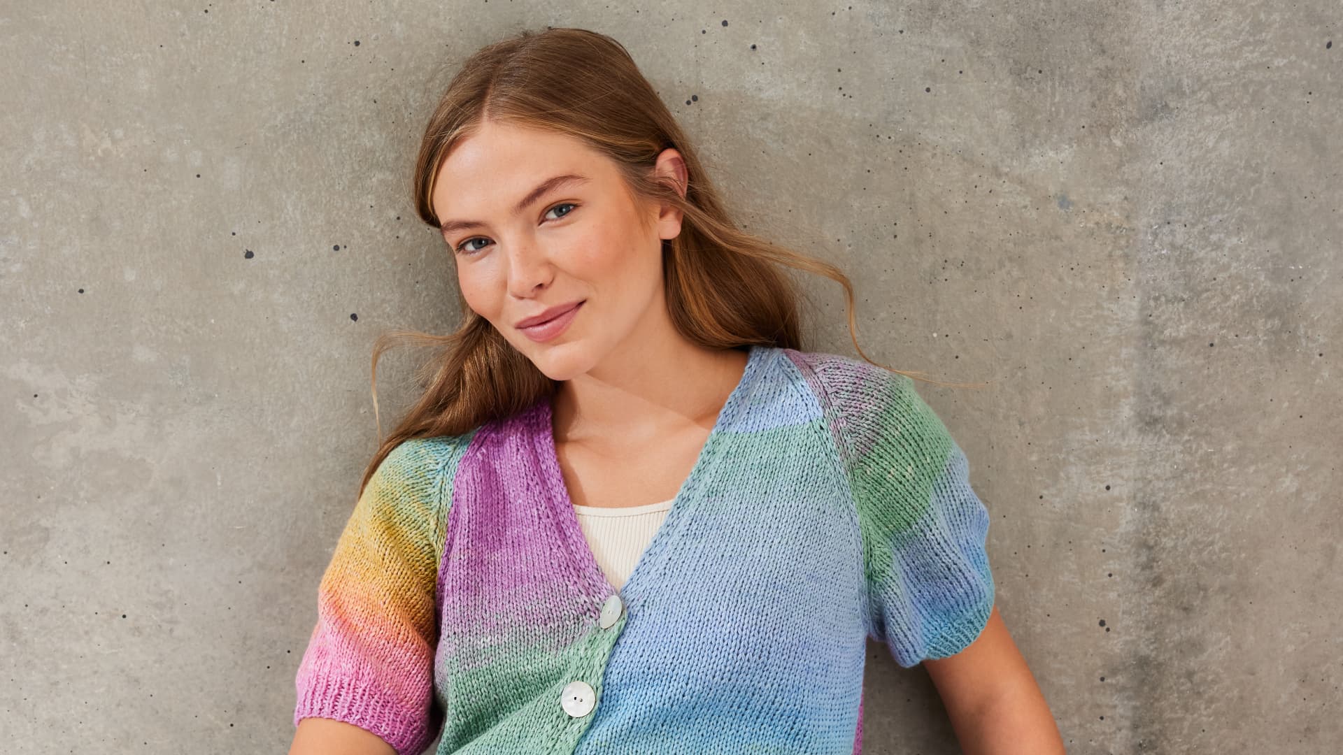 Strickanleitung für die farbenfrohe Strickjacke mit Puffärmeln von Lana Grossa Model in gestrickter Strickjacke mit Puffärmeln von Lana Grossa