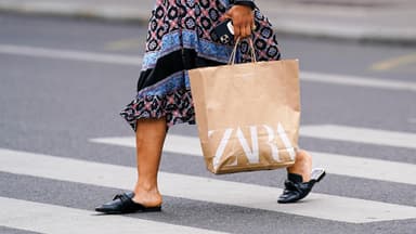 Frau trägt Zara Shoppingtüte Frau trägt Zara Shoppingtüte