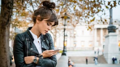 Versetzt beim ersten Date – das ist Cloaking. Frau schaut wartend auf ihr Handy.