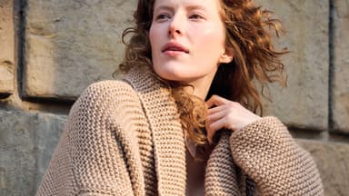 Strickanleitung für die Strickjacke mit Schalkragen von Lana Grossa Model mit beiger Strickjacke mit Schalkragen von Lana Grossa