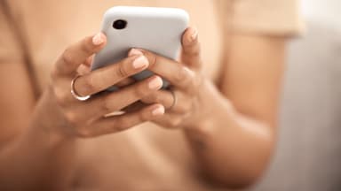 Nicht nur Stars, auch normale Menschen werden immer öfter Opfer von Deepfakes Frau schaut auf ihr Smartphone