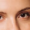 Pflegende Mascaras vereinen Volumen, Länge und Wirkstoffe in sich Frau mit pflegender Mascara auf den Wimpern