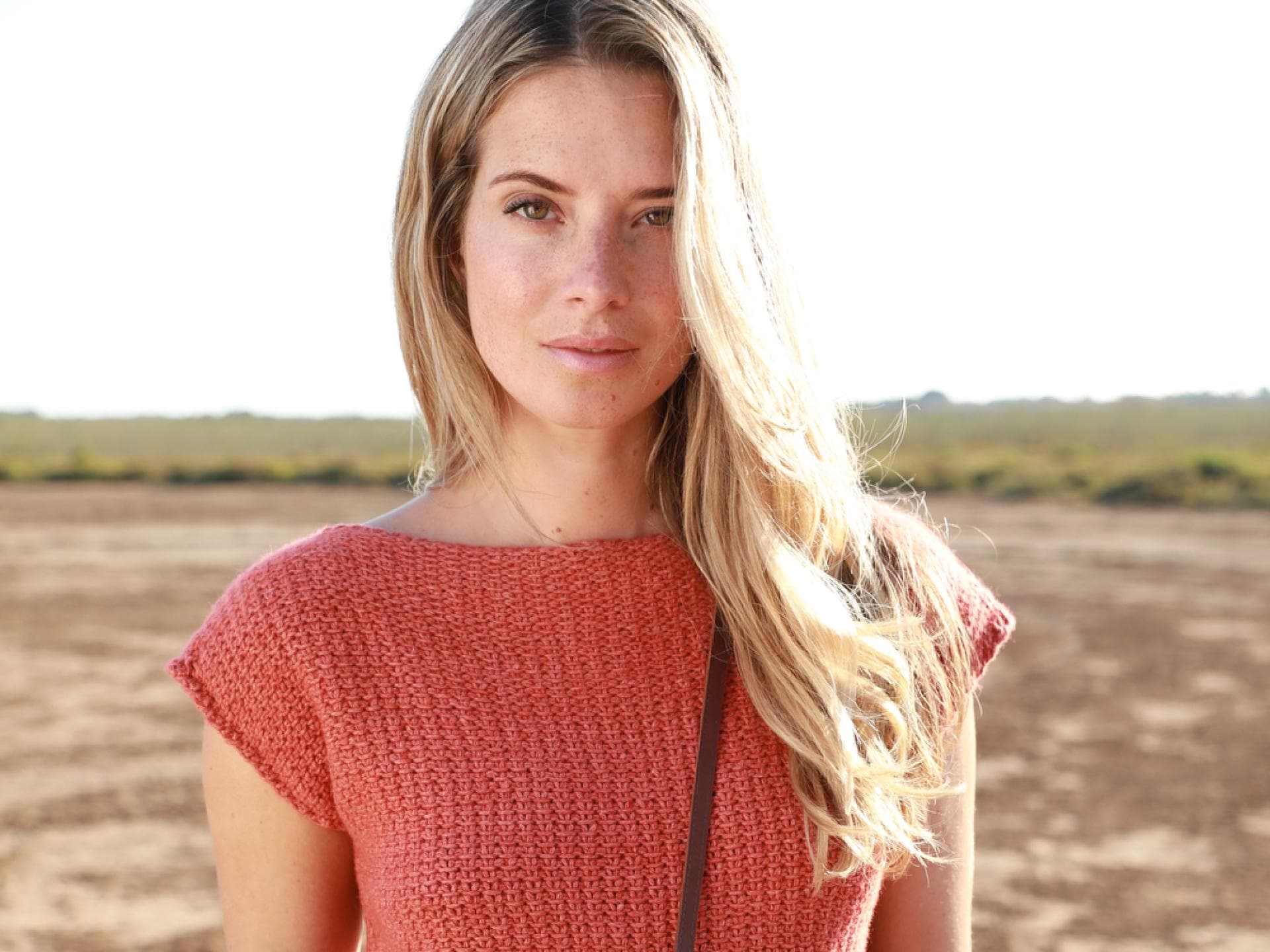 Strickanleitung für das rote Top von Lana Grossa Model trägt rotes Strick-Shirt von Lana Grossa