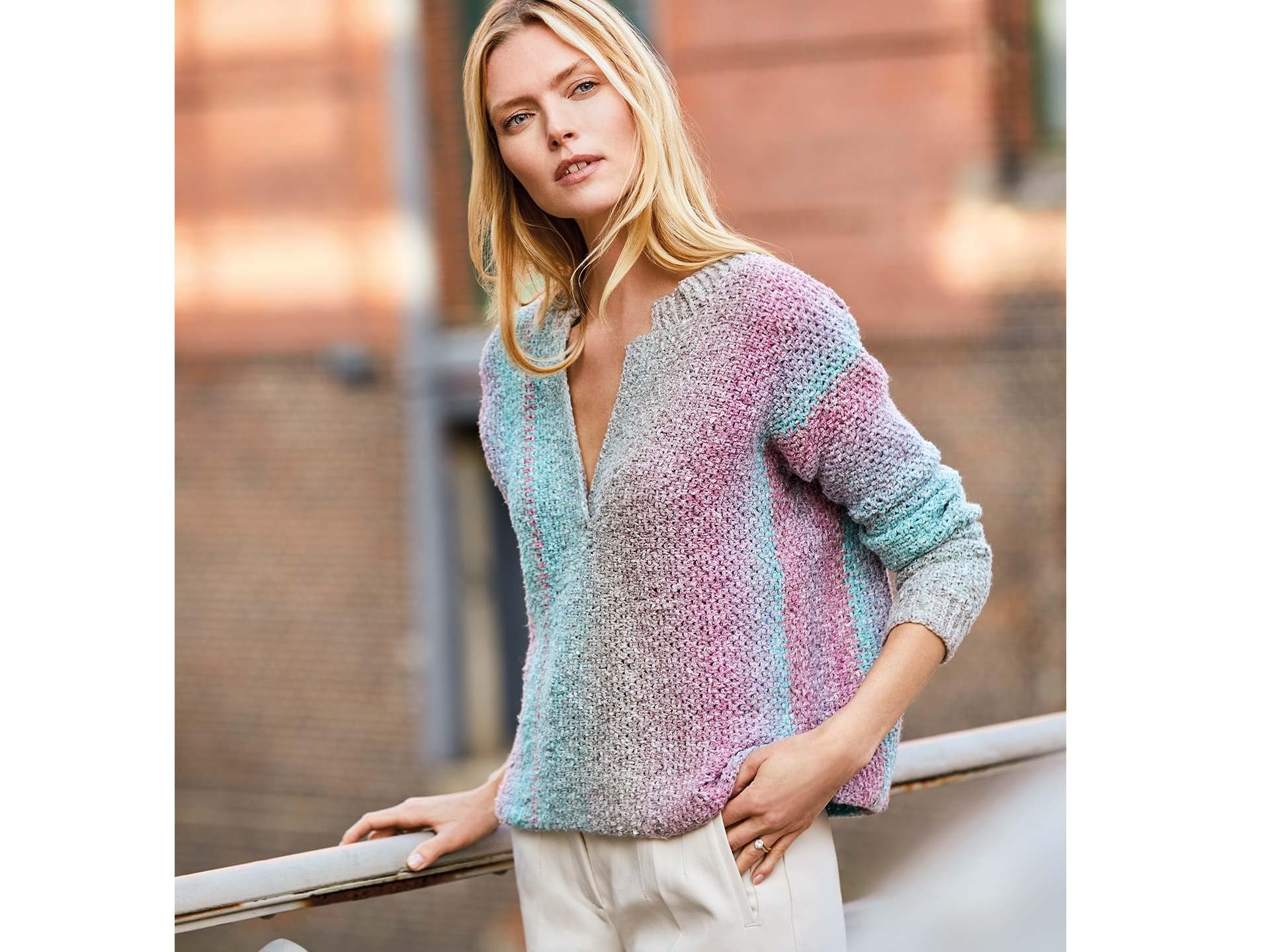 Model in farbenfrohem Ringelpullover mit V-Ausschnitt von Lana Grossa Model in farbenfrohem Ringelpullover mit V-Ausschnitt von Lana Grossa