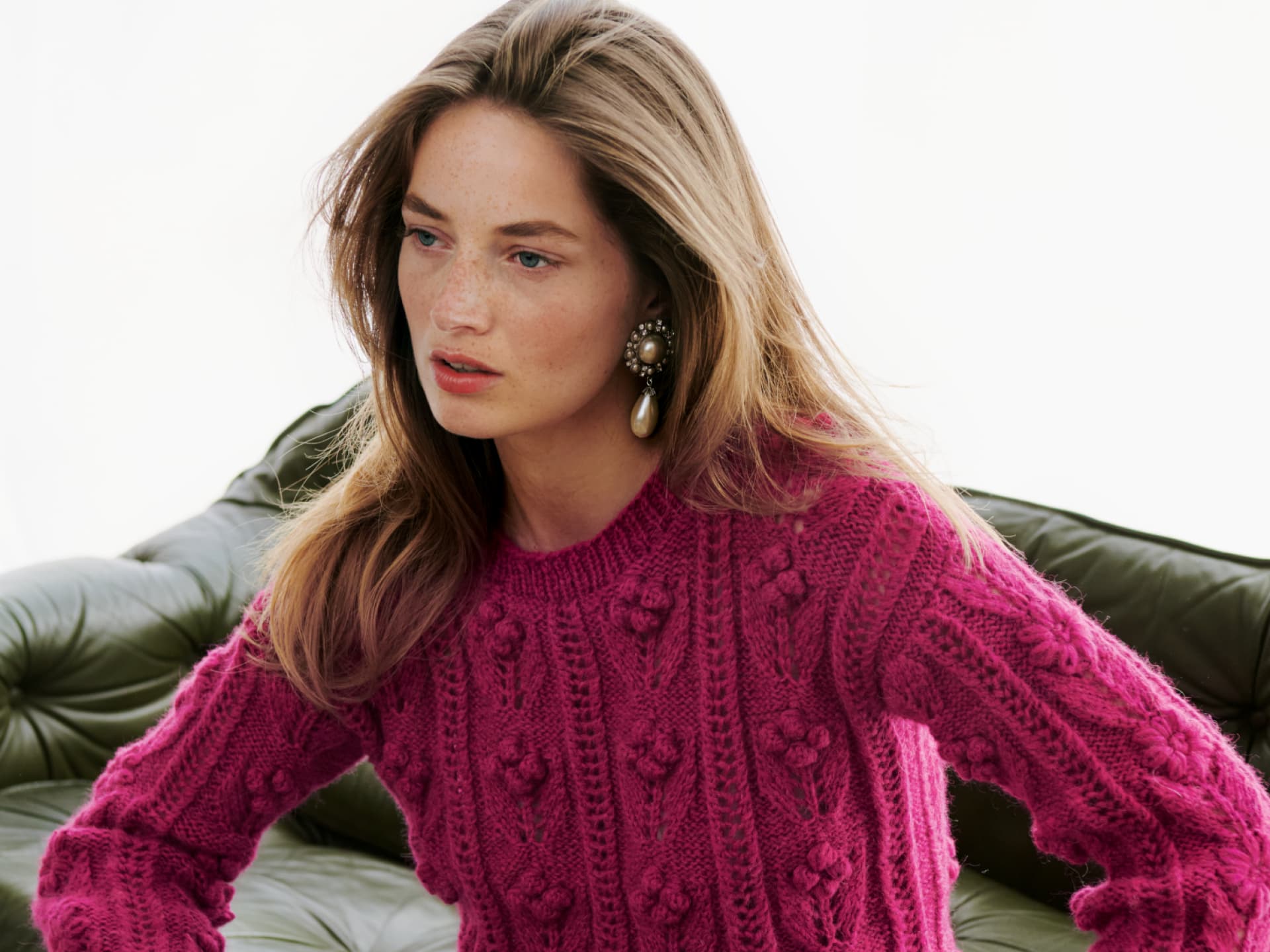 Model in Zopfmusterpullover mit Blüten von Lana Grossa Model in Zopfmusterpullover mit Blüten von Lana Grossa