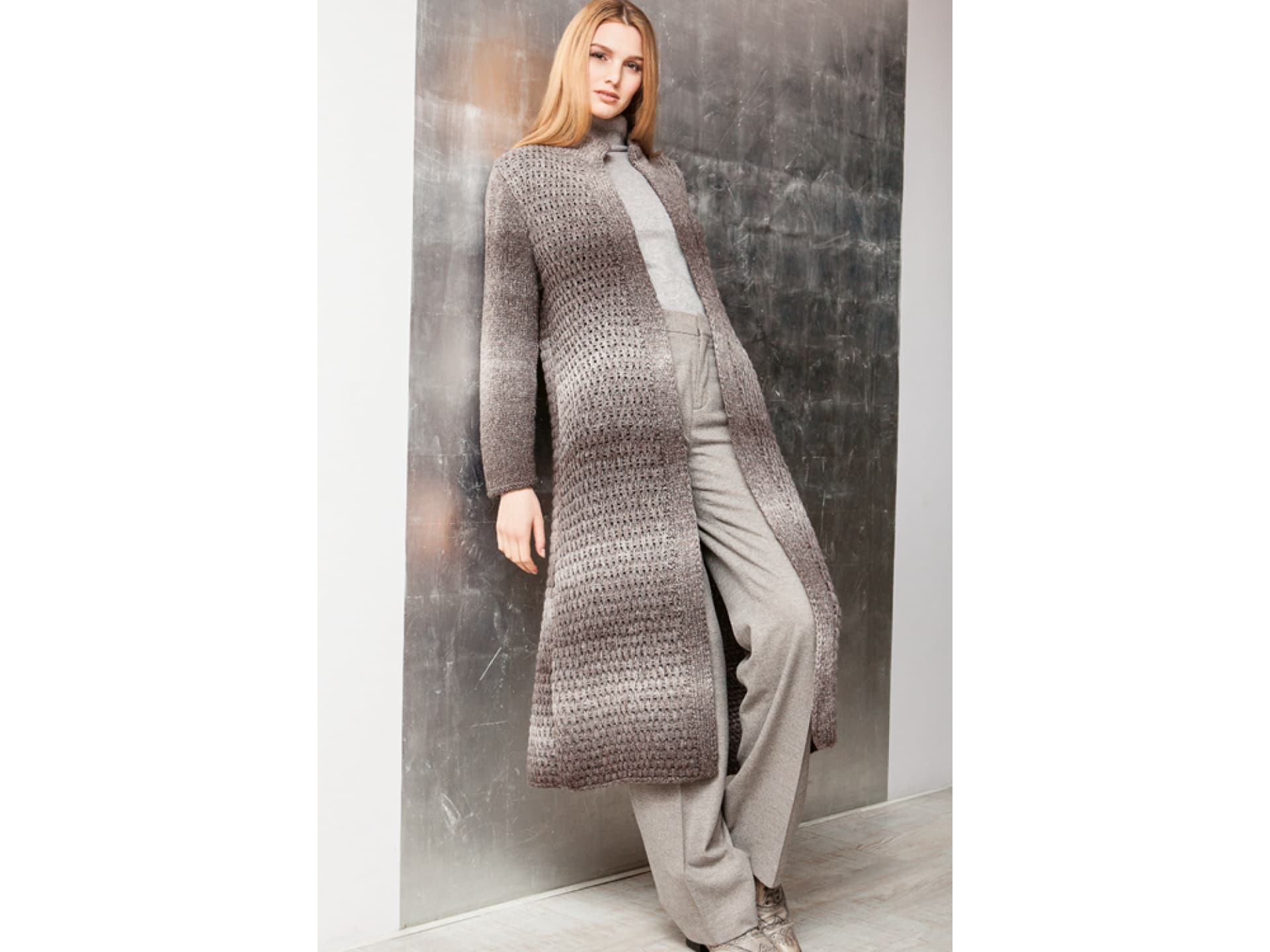 Model in Strickmantel mit Hebemaschenmuster Model in Strickmantel mit Hebemaschenmuster