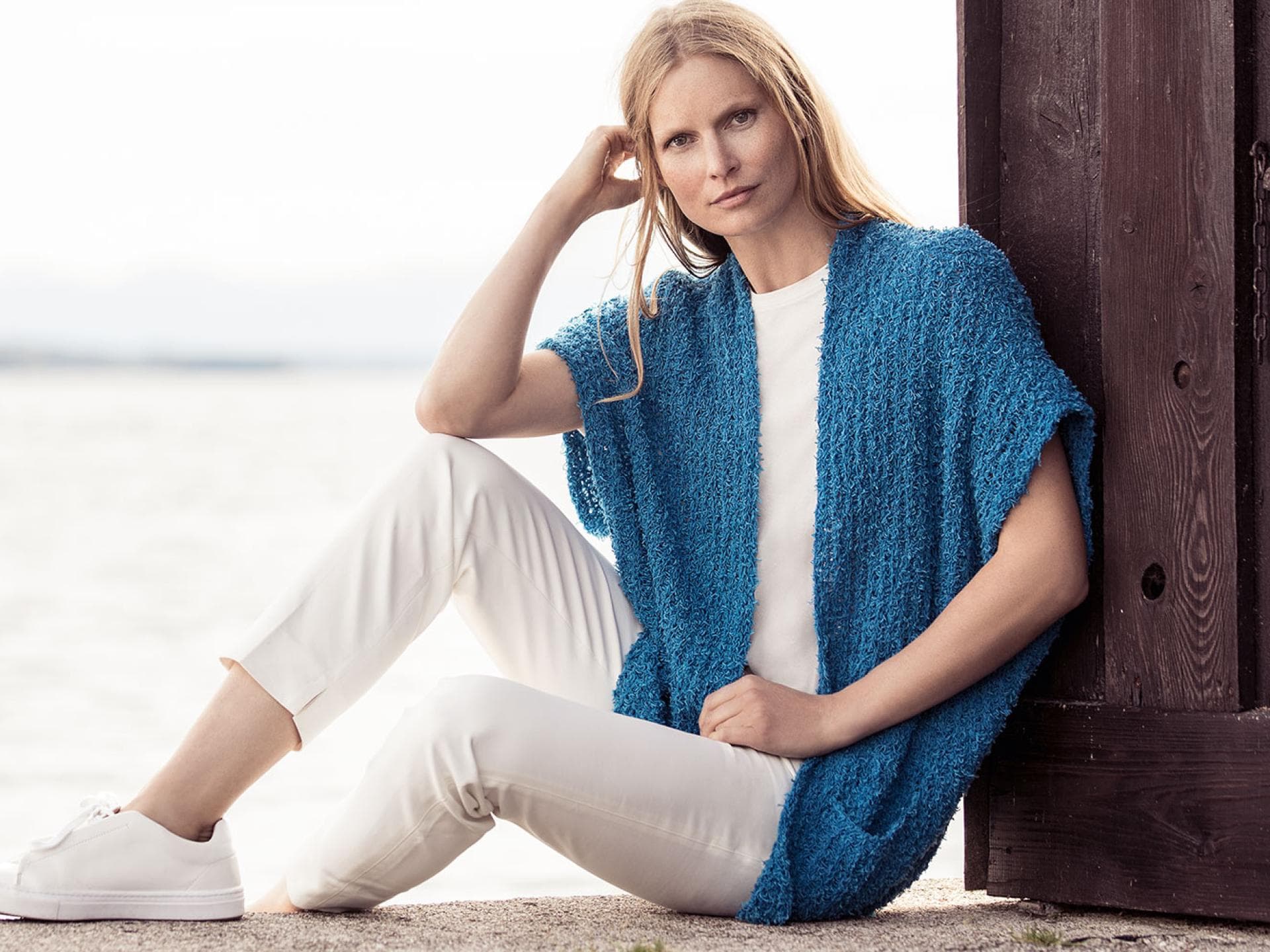 Model in blauer Oversize-Strickjacke von Lana Grossa Model in blauer Oversize-Strickjacke von Lana Grossa