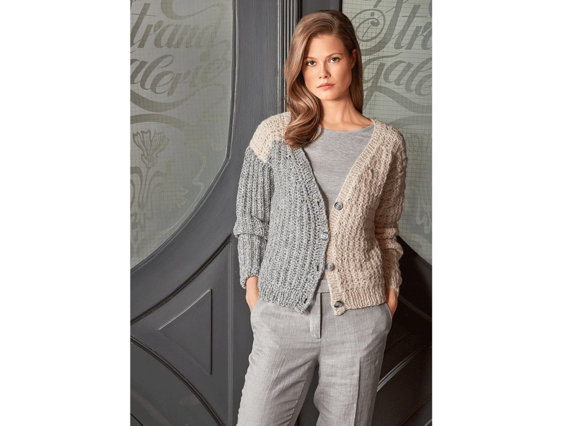 Model in zweifarbig gestrickter Strickjacke Model in zweifarbig gestrickter Strickjacke
