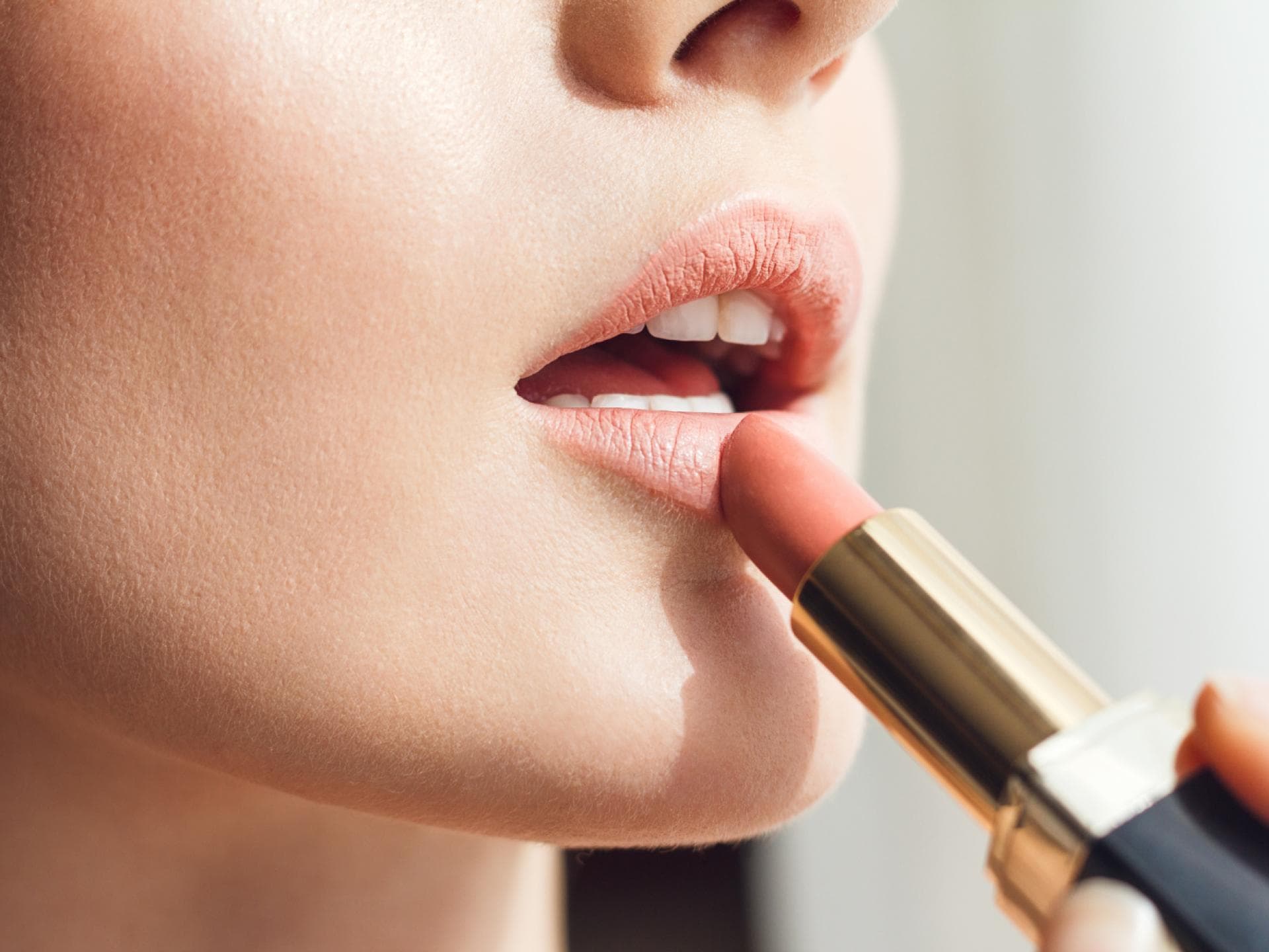 Frau trägt selbst gemachten Lippenstift auf Frau trägt selbst gemachten Lippenstift auf