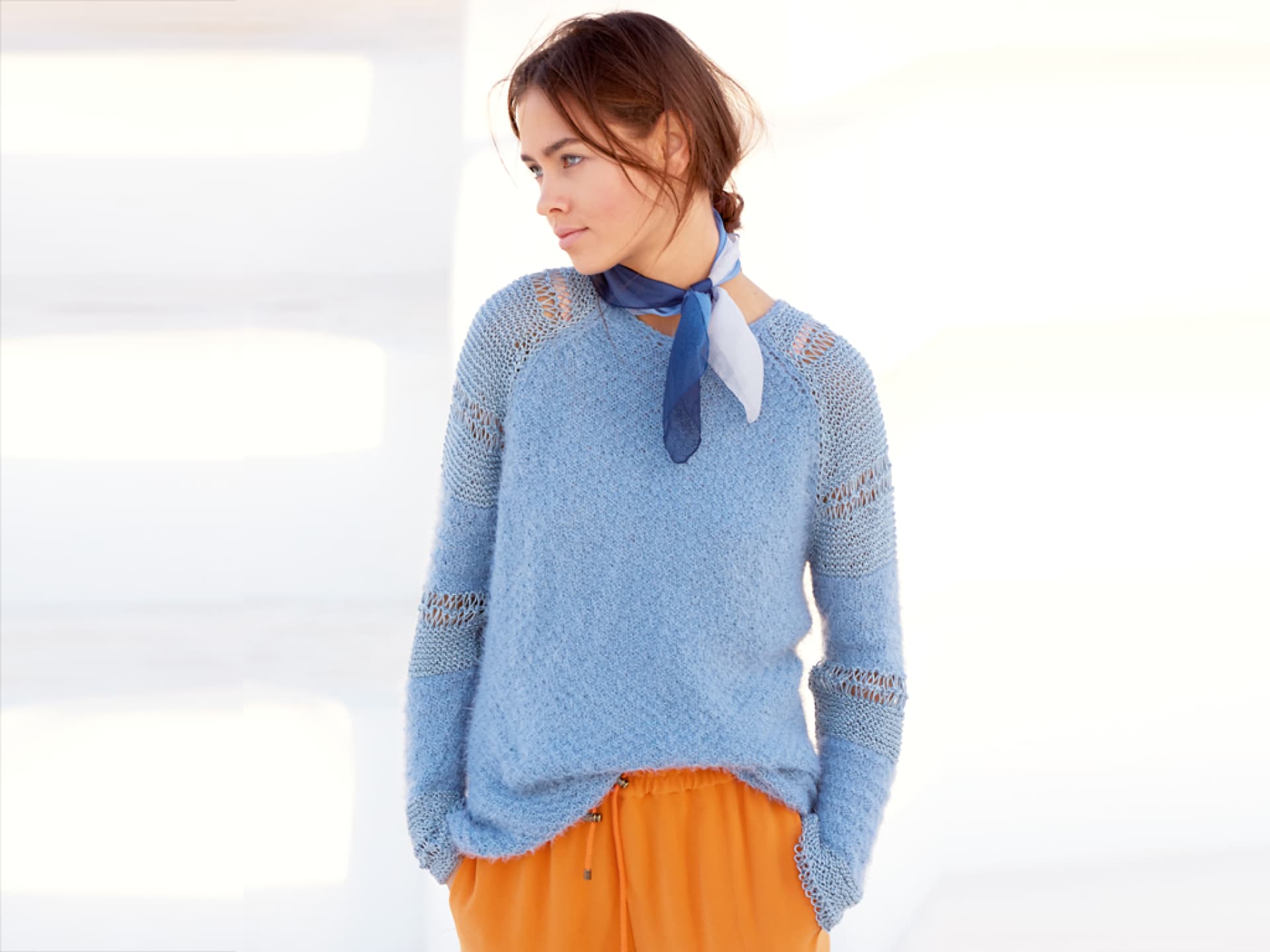Model in eisblauem Raglanpullover mit Lochmuster Model in eisblauem Raglanpullover mit Lochmuster
