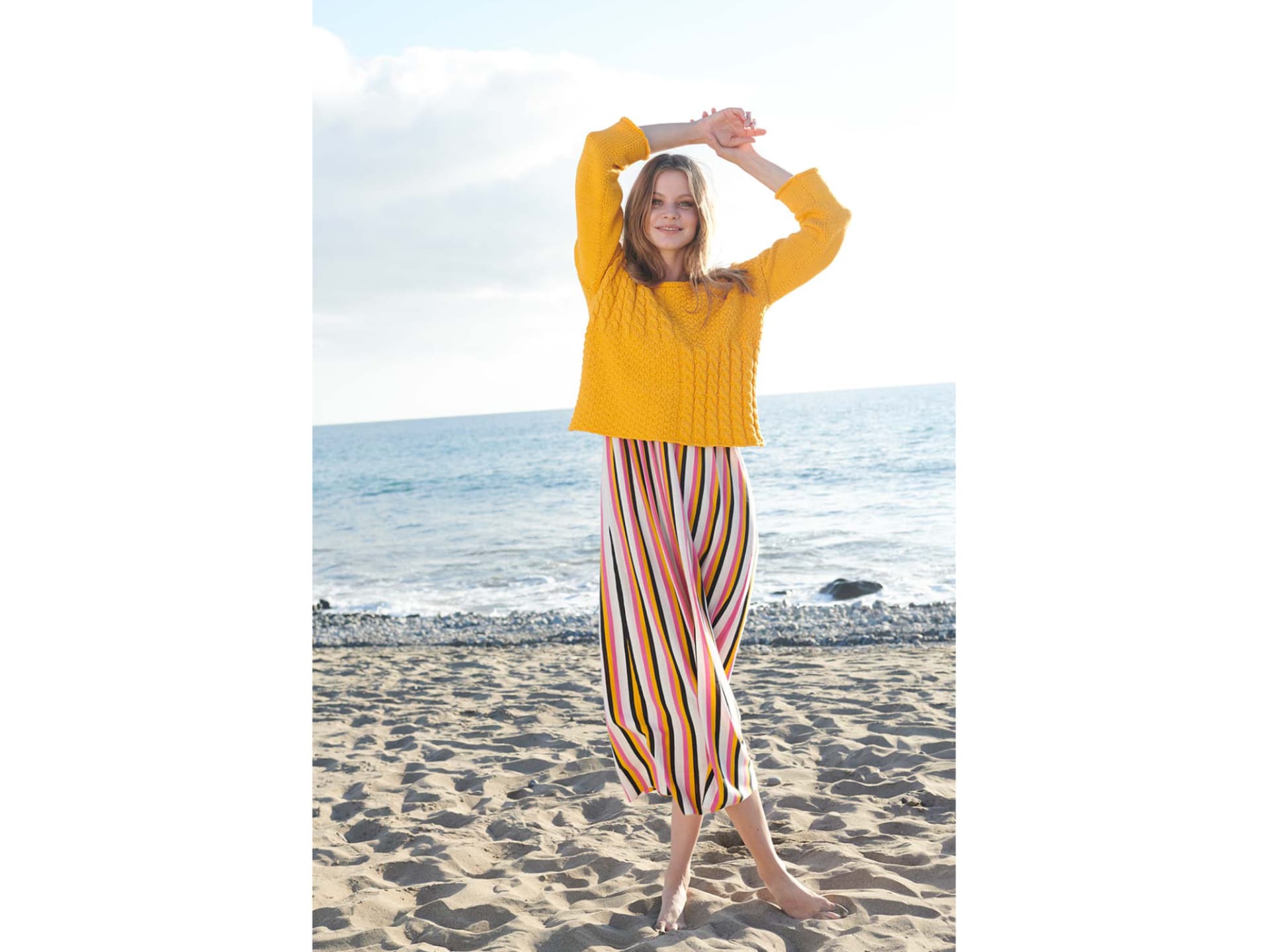 Model in gelbem Sommerpulli mit Zopfmuster Model in gelbem Sommerpulli mit Zopfmuster