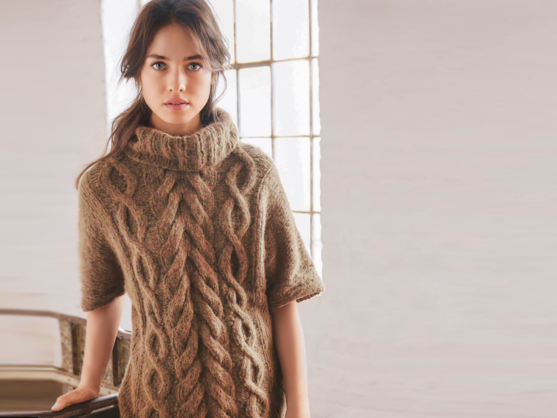 Model in braunem Zopfstrickpullover mit kurzen Ärmeln von Lana Grossa Model in braunem Zopfstrickpullover mit kurzen Ärmeln von Lana Grossa