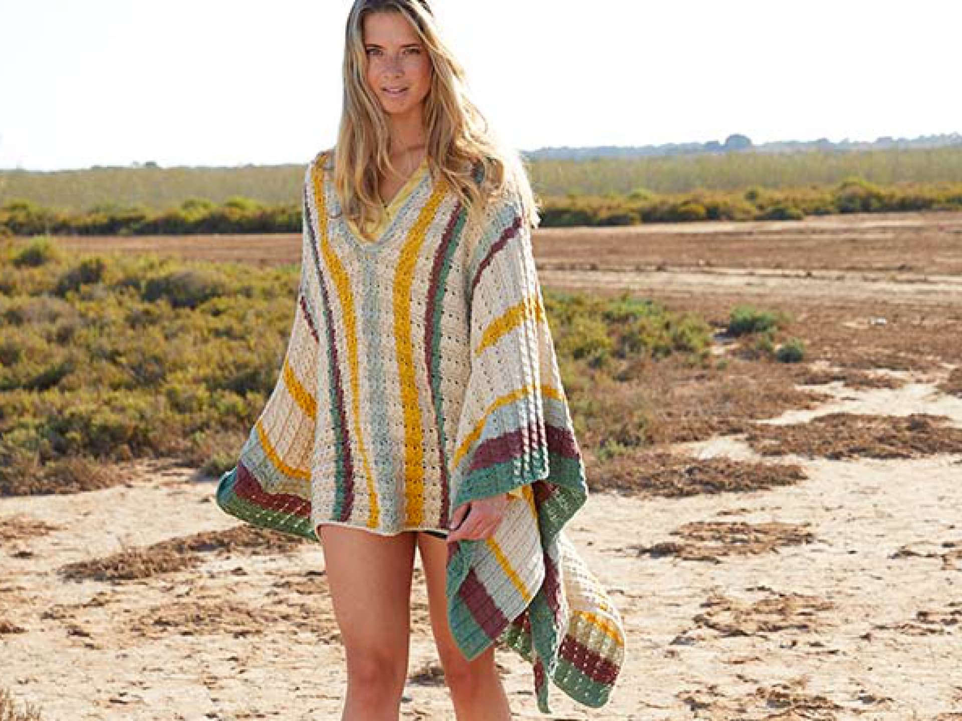 Strickanleitung für ein buntes Poncho-Kleid von Lana Grossa Model in einem bunten Poncho-Kleid von Lana Grossa