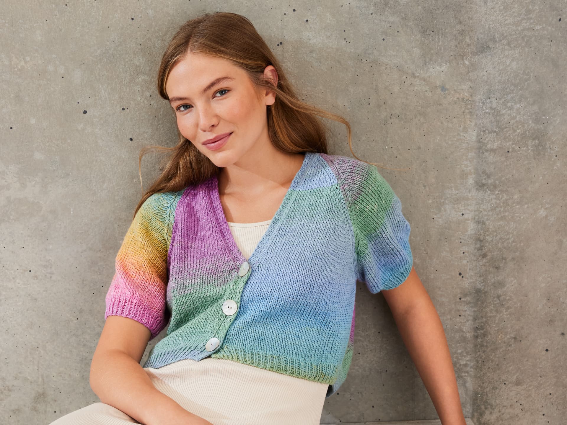 Strickanleitung für die farbenfrohe Strickjacke mit Puffärmeln von Lana Grossa Model in gestrickter Strickjacke mit Puffärmeln von Lana Grossa