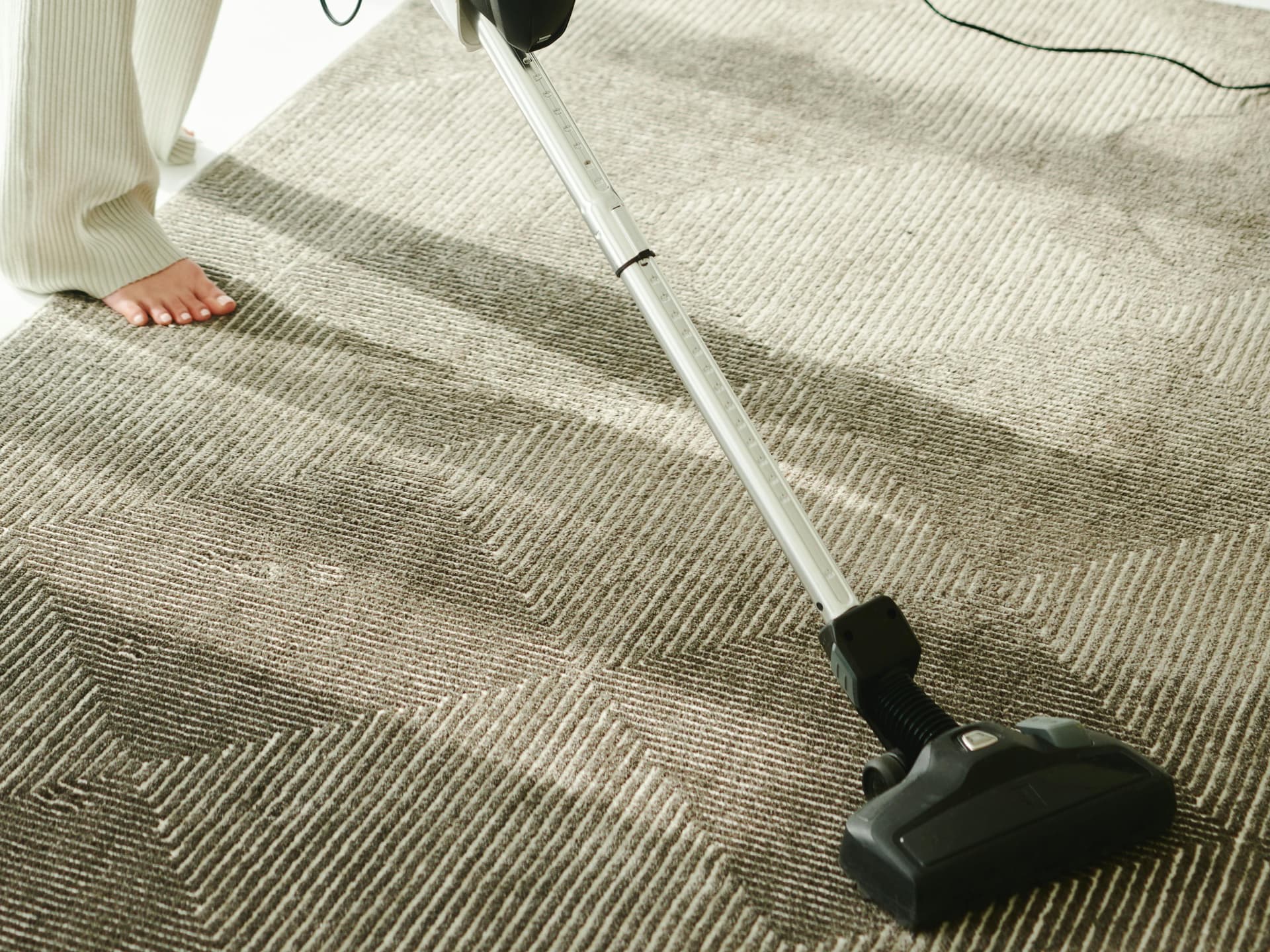 Den leisesten Staubsauger? Haben wir bei Miele entdeckt! Frau reinigt Teppich mit dem leisesten Staubsauger