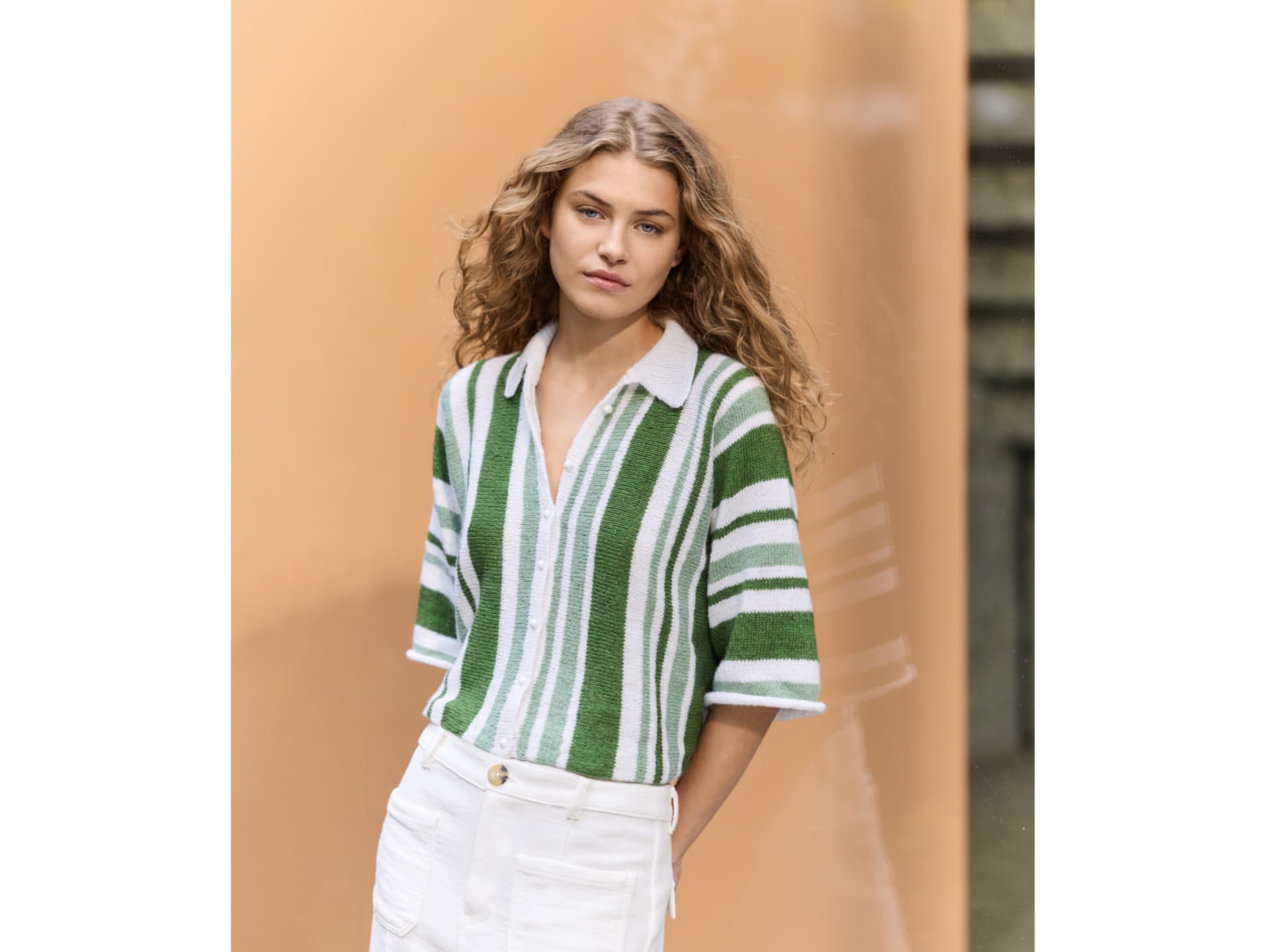 Die Polojacke kann als Shirt oder kurzärmlige Strickjacke getragen werden Model in gestrickter Polojacke von Lana Grossa