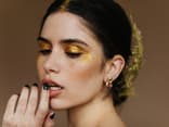 Frau mit goldenem Glitzer-Lidschatten Frau mit goldenem Glitzer-Lidschatten