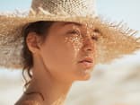 Beim Auftragen von Sonnencreme unter Make-up gibt es ein paar Dinge zu beachten Frau mit Sonnencreme unter Make-up