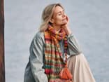 Bei uns finden Sie viele kostenlose Strickanleitungen für den Herbst Model mit buntem Strickschal von Lana Grossa