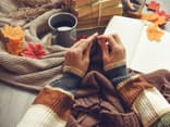 Ich stelle Ihnen die besten Strickbücher vor! Frau strickt und hat ein Strickbuch parat