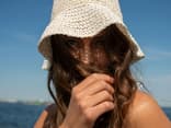 Wir stellen Ihnen die besten Sonnencremes für empfindliche Haut vor Frau mit bester Sonnencreme für empfindliche Haut im Gesicht
